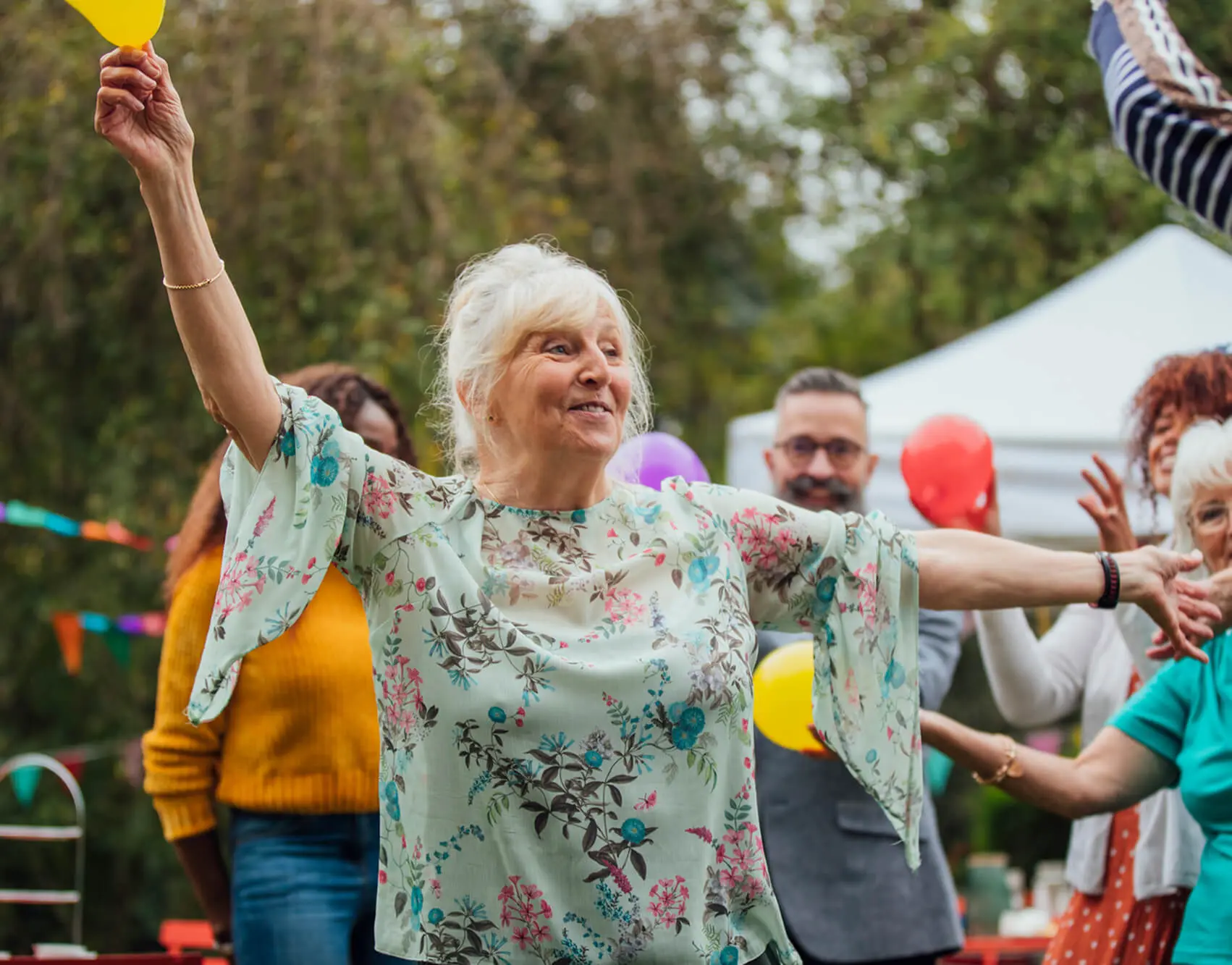 Elderly woman dancing at outdoor party